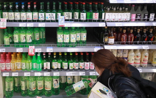 대형마트 주류 코너에서 한 소비자가 제품을 고르고 있다.       청탁금지법 시행으로 집에서 혼자 술을 즐기는 '혼술족'이 증가하고 비선실세 국정농단 정국 속에 '홧술족'까지 가세해 대형마트 주류 판매가 10월 이후 큰 폭의 신장세를 보이는 것으로 나타났다.